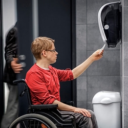 Mand i kørestol bruger Katrin system håndrulle dispenser